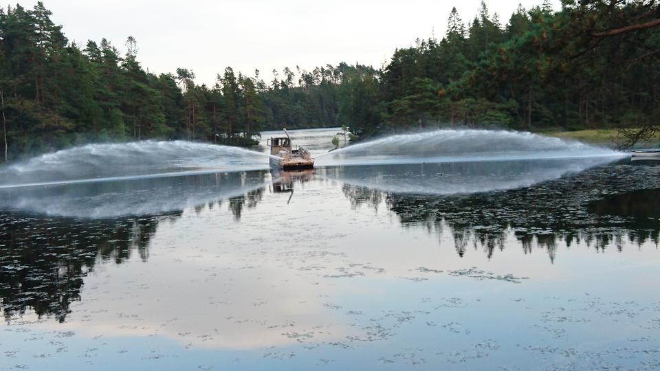 En båt som sprutar kalk i Gårdsjön